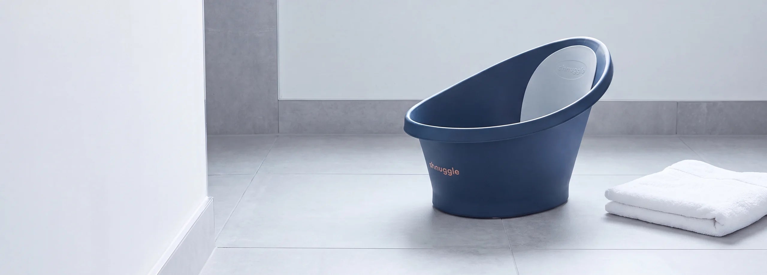 Banheira de bebé Shnuggle azul-noite numa casa de banho clara